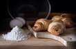 © medea83 - Several croissants on cutting board next to flour, glass with milk, eggs. fresh pastry, bakery.