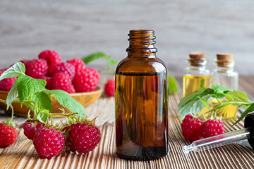 Wall Mural - A bottle of raspberry seed oil with fresh raspberries