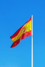 Spanish Flag Waving Against Clear Blue Sky