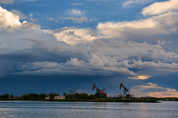 Wall Mural - The oil pumping units  and cloudscape sunset.