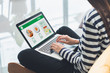 © weedezign - Asian woman cross leg sitting at couch use laptop to order food online in website at home.digital leisure convenient lifestyle.Food and drink business concept.