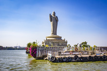 Sailing By The Giant Buddha Statue With Bright Pink Bougainvillea Plants In The Middle Of Hussain Sagar Lake In Hyderabad, India