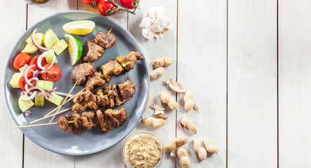 Traditional pork satay with peanut sauce and vegetables