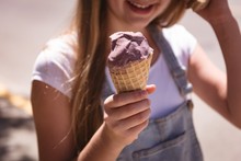 Girl Hand Holding Waffle Cone With Ice Cream On A Sunny Day