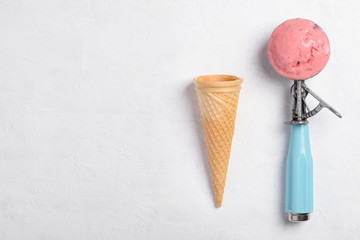 Ice cream spoon with homemade icecram scoop with wafer cone on white table background topview flatlay with copy space