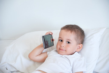 baby boy before going to bed and watching cartoons in the smartphone