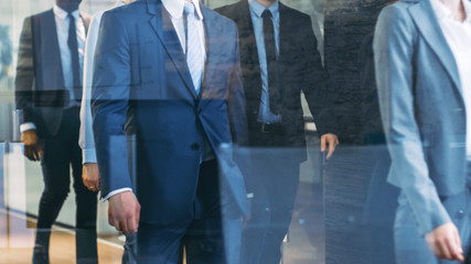 Diverse Team of Delegates/ Lawyers Led by Woman Confidently Marches Through the Corporate Building Hallway. Multicultural Crowd Of Resolute Business People in Stylish Marble and Glass Offices.