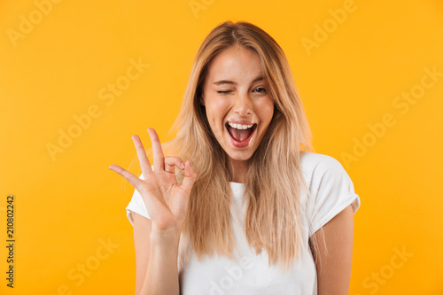 Photographie Portrait of a happy young blonde girl showing ok gesture