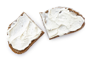 Wall Mural - Two half slices of rye bread with cream cheese spread isolated on white from above.