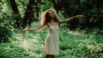 young and beautiful girl dancing ballet in the secret garden. natural scenery in the forest.