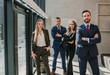 © ADDICTIVE STOCK - Business colleagues standing with crossed arms