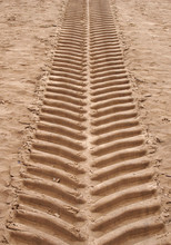 Wide Vertical Straight Single Tyre Print In Sand Running Upwards With Deep Tread Pattern
