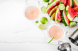 Alcoholic summer beverage, watermelon martini cocktail, with fresh lime and mint, white marble background copy space top view