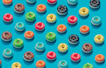 Wall Mural - Creative pattern of colorful donuts on pastel blue background. Minimal food concept. Isometric.