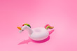 Inflatable unicorn pool toy on pastel pink background. Minimal summer concept.