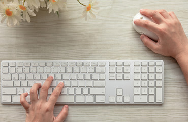 Working at home office hands typing on computer keyboard and mouse on the table desk .Wireless input device technology concept .top view