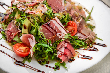 salad with parma ham jamon , tomatoes and arugula