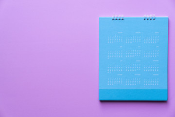 close up of blue calendar on pink background, planning for business meeting or travel planning concept