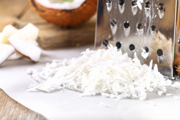 Wall Mural - Fresh Grated Coconut, detailed close-up shot, on wooden background.