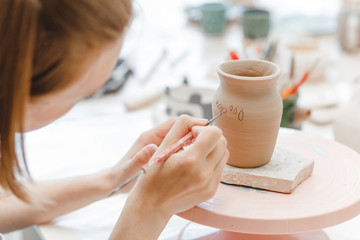 Wall Mural - Workshop of clay pottery ceramic, woman decorating dishware pot