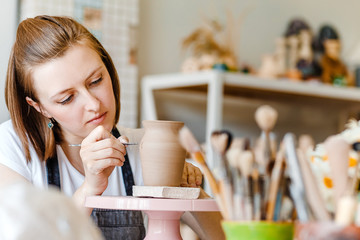 Wall Mural - Workshop of clay pottery ceramic, woman decorating dishware pot