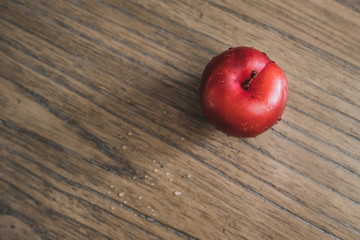 Red nectarine with drops of water on a wooden table