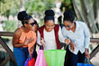 © AS Photo Family - Three casual african american girls with colored shopping bags walking outdoor. Stylish black womans shopping.