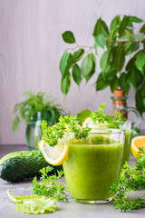 Refreshing smoothies from cucumber, green apple, fresh herbs and lemon juice in transparent glasses on the table. The concept of a healthy diet. Vegetarian menu