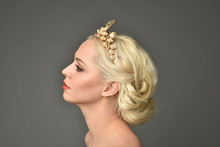 Portrait Of Blonde Woman Wearing Golden Crown, Grey Studio Background.
