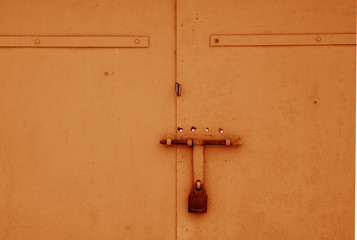 Wall Mural - Old padlock on metal gate in orange color.