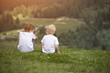© somemeans - Two boys sit on the hill and talking cheerfully. Back view