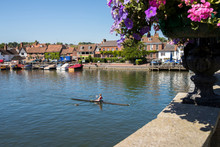 Skyline Of Henley On Thames In Oxfordshire UK With Rower On River Thames In Foreground