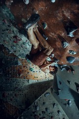 Wall Mural - Free climber young man climbing artificial boulder indoors