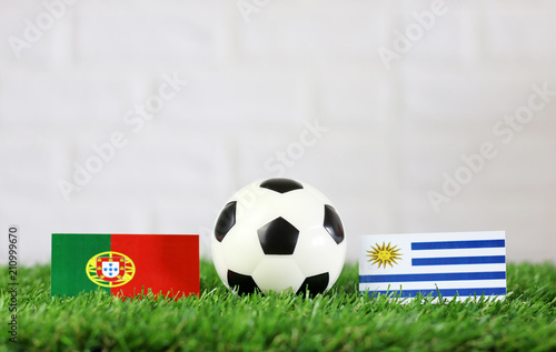 Ball With Uruguay Vs Portugal Flag Match On Green Grass