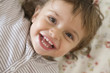 © Maria - Baby girl, 23 months, Toddler, Overhead shot, teeth, toothless, button, flowered, bed linen