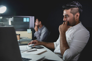 Wall Mural - Asian businessmen staying overtime late at night working in the office