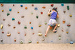little girl climbing a rock wall outdoor at children playground