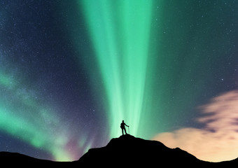 Wall Mural - aurora and silhouette of standing woman on the top of mountain. lofoten islands, norway. aurora bore