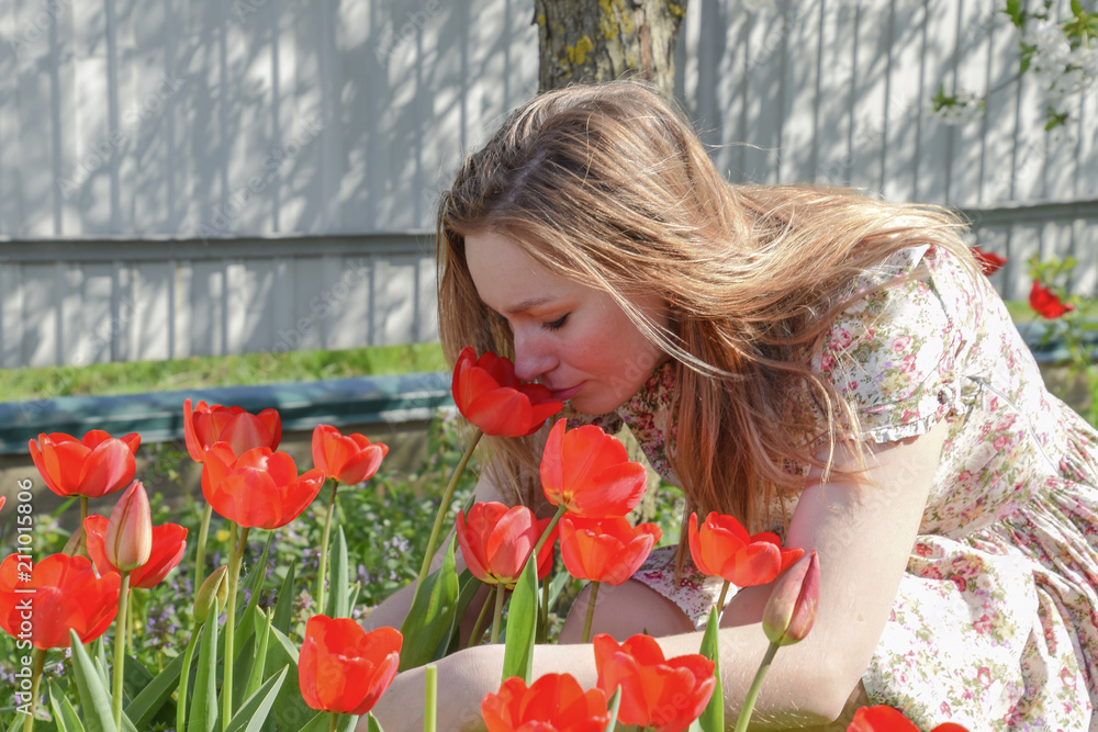 Sniff Spring Girl sniffing tulips. The girl among the flowers Stock Photo | Adobe Stock