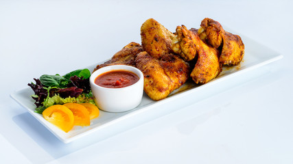 Wall Mural - Appetizing spicy baked chicken wings with sweet chili sauce on t