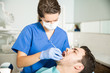 © AntonioDiaz - Dentist Examining Man With Dental Carver At Clinic