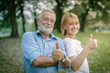 Happy elderly senior couple in park with good health action concept