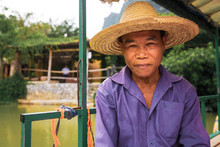 Portrait Of Fisherman In Straw Hat Sitting Outdoors