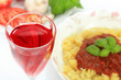 Lampka czerwonego wina i makaron spagetti z sosem neapolitańskim.