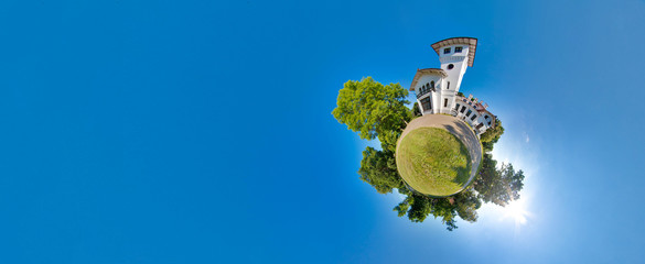 Green little planet with trees, soft blue sky and building. Tiny planet sunset near the castle. 360 viewing angle. Planet Earth.