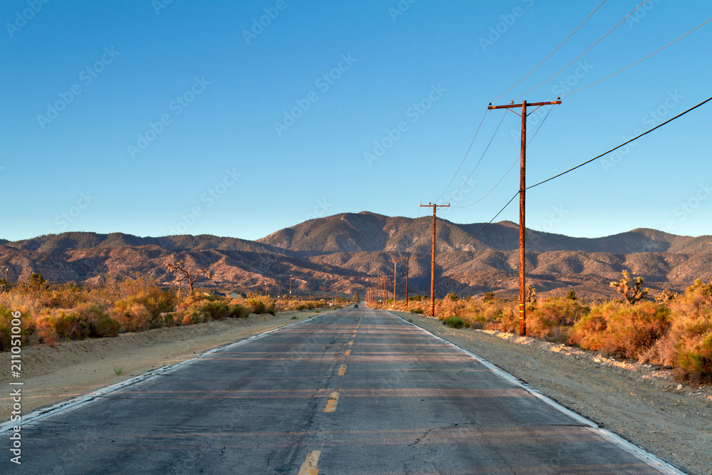 Single country road in the Mojave Desert facing mountains in a early morning drive. - obrazy, fototapety, plakaty 