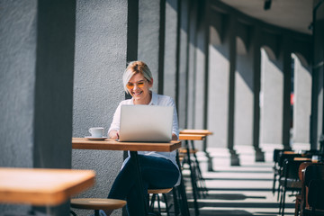 Young woman drinking coffee and checking email