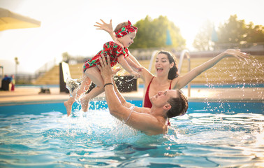 beautiful family having fun in a swimming pool