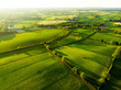 Aerial view of endless lush pastures and farmlands of Ireland. Beautiful Irish countryside with emerald green fields and meadows.