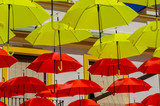 Fototapeta Uliczki - Colourful umbrellas urban street decoration. Hanging colorful umbrellas over blue sky, tourist attraction